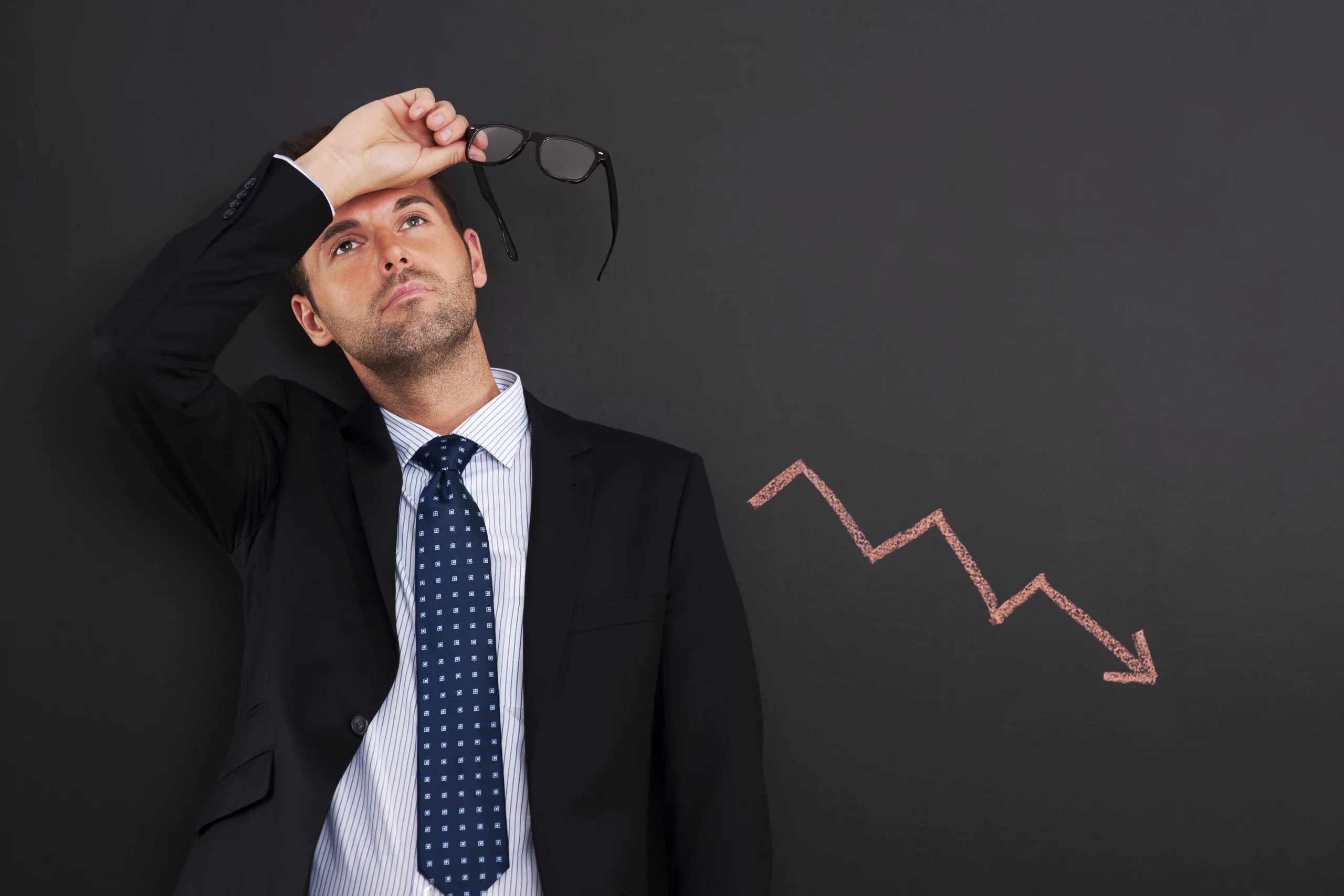 worried businessman with sign decreased profit scaled 1